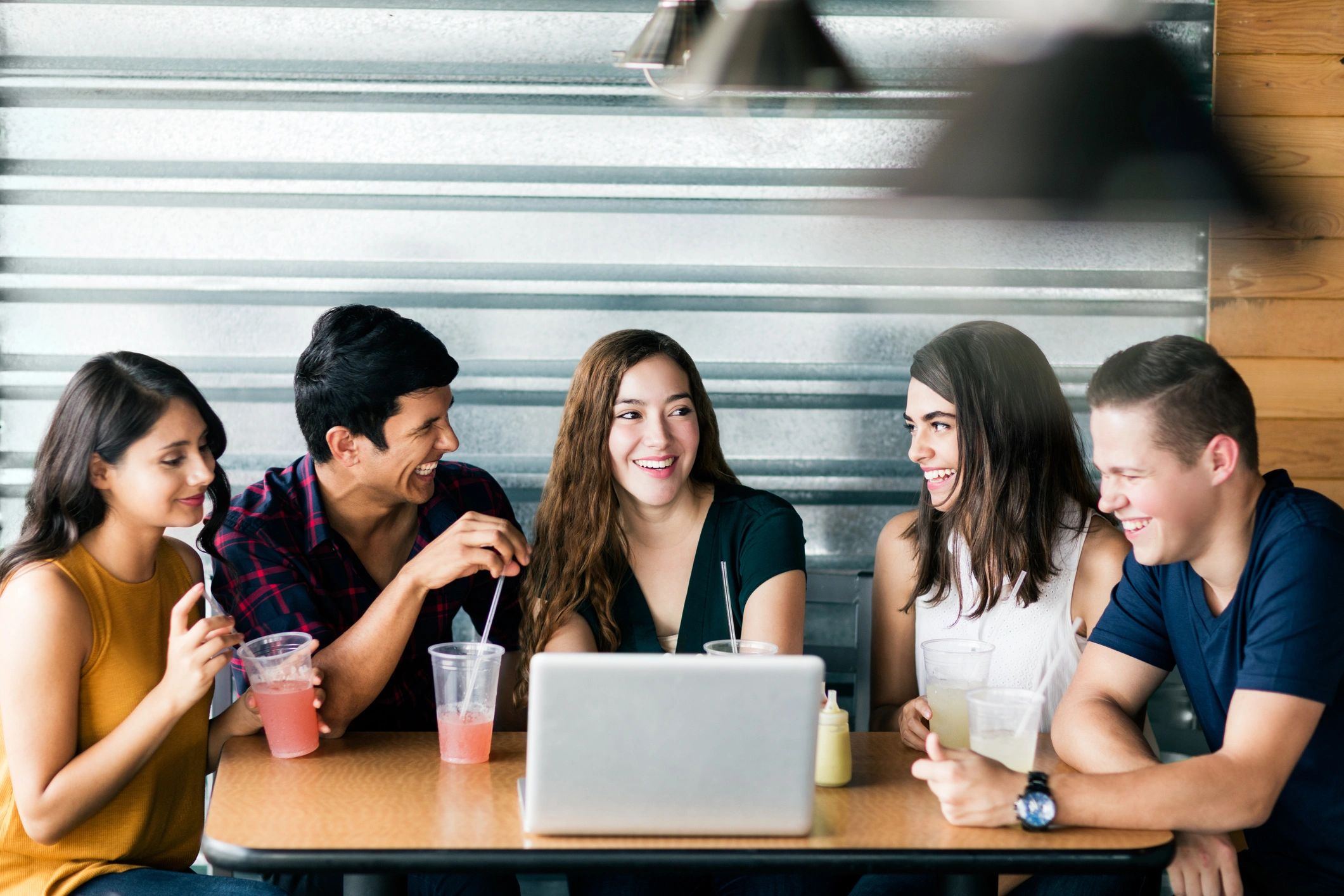 Friends gathered around a laptop in discussion